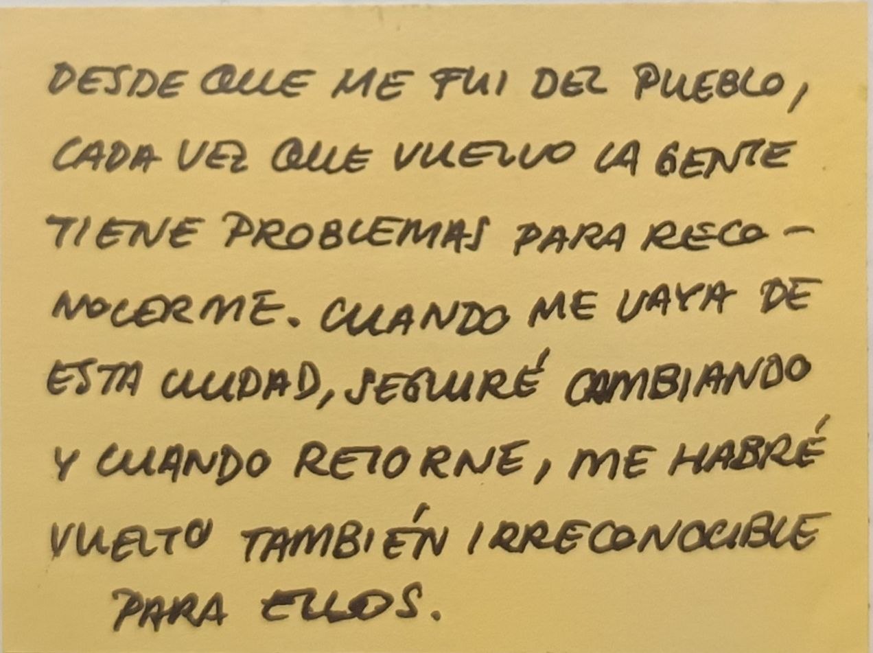 post-it que dice: desde que me fui del pueblo, cada vez que vuelvo la gente tiene problemas para reconocerme. Cuando me vaya de esta ciudad, seguiré cambiando y cuando retorne, me habré vuelto también irreconocible para ellos.